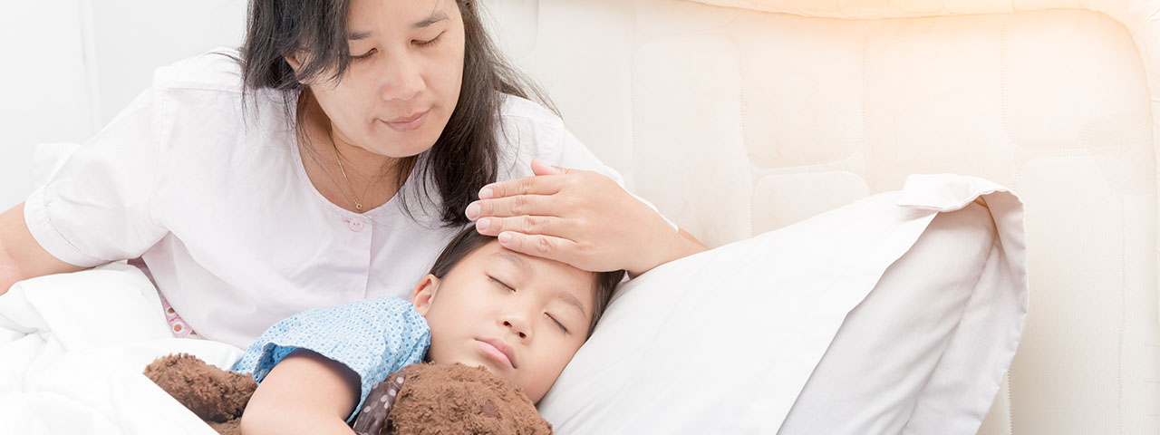 cosinuss-degree-einzelbild-sick-girl-laying-in-bed-and-mother-hand-taking-original_temperature-sick-child-with-fever-and-illness_688361116 sick child laying in bed with mother measuring fever with her hand