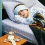 Complications Fever: feverish child sick in bed treated with cold wraps, hot drinks and medication