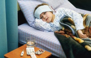 Complications Fever: feverish child sick in bed treated with cold wraps, hot drinks and medication