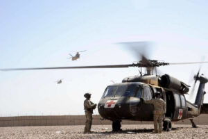 Ein medizinischer Verteidigungshubschrauber ist startbereit, während zwei Soldaten noch außen vor dem Hubschrauber stehen.