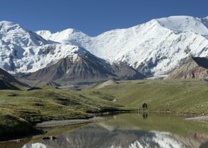 Lenin Peak Basecamp with snowy mountains in the background and a blue sky