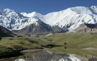 Lenin Peak Basecamp with snowy mountains in the background and a blue sky