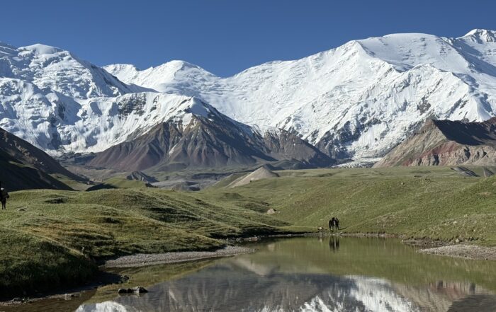 Lenin Peak Basecamp with snowy mountains in the background and a blue sky